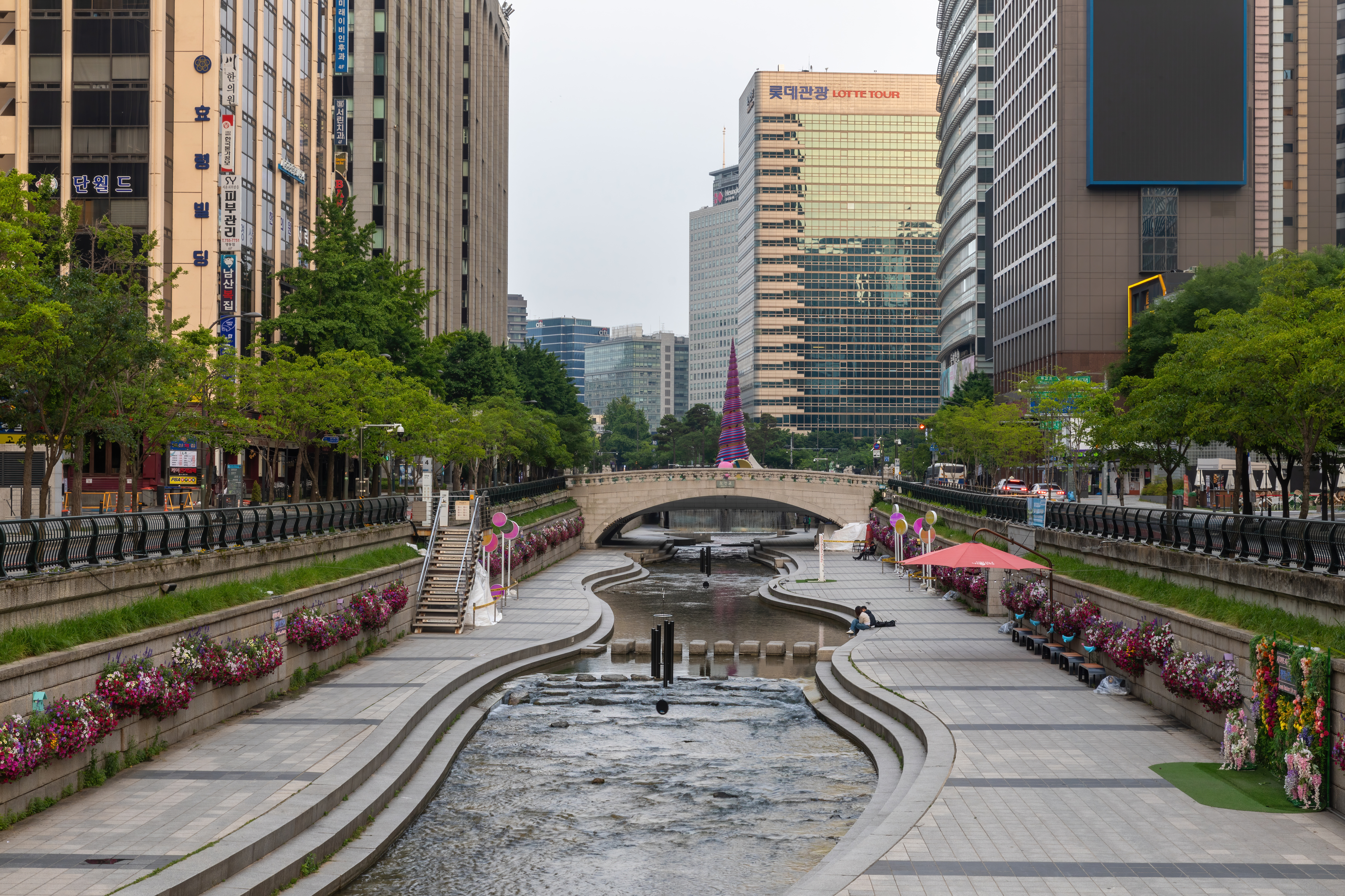 Cheonggyecheon stream with flowers and bridge at sunrise near Cheonggye Plaza in Seoul